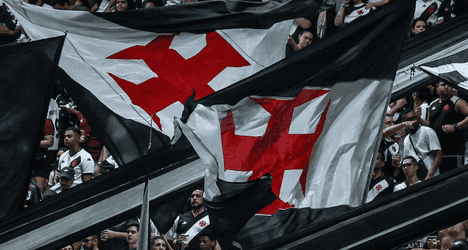 Bandeira do Vasco sendo agitada por torcedores.