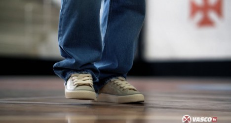 Técnico de futebol com calçados esportivos.