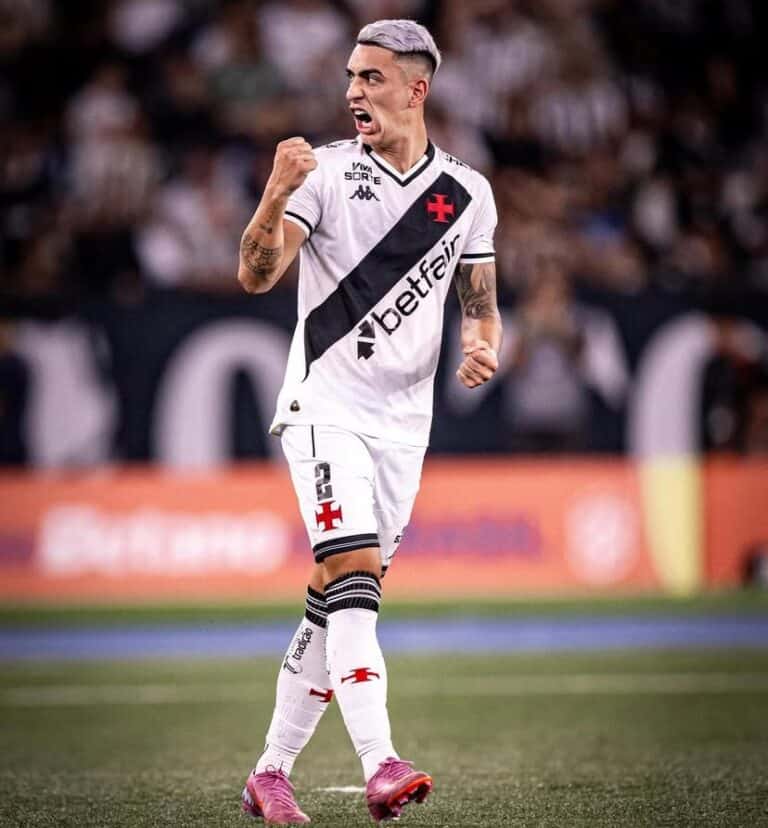 Jogador comemorando gol com força, usando uniforme do Vasco.