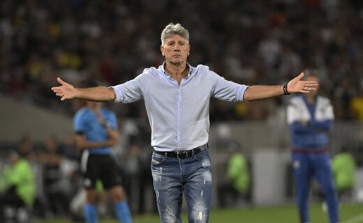 Treinador Vasco com braços abertos em campo.