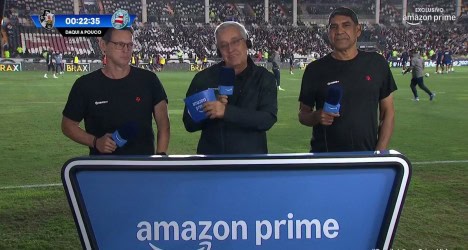 Homens apresentando em estádio com banner da Amazon Prime.
