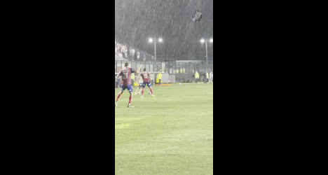 Jogadores treinando no campo à noite.