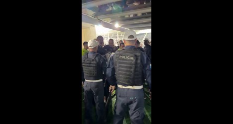 Seres policiais em ação em local fechado.