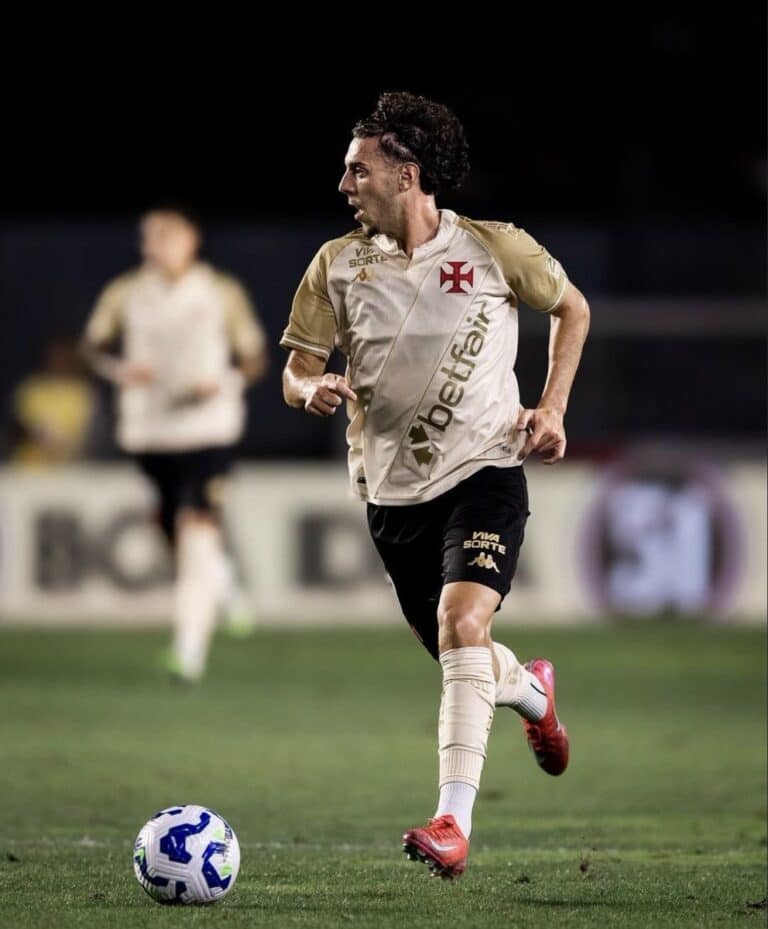 Jogador do Vasco driblando com a bola em campo.