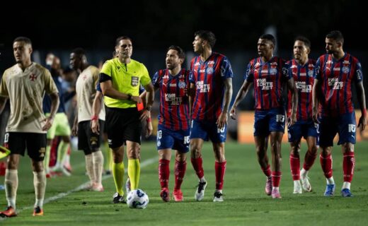 Jogadores do Vasco em campo durante jogo noturno.