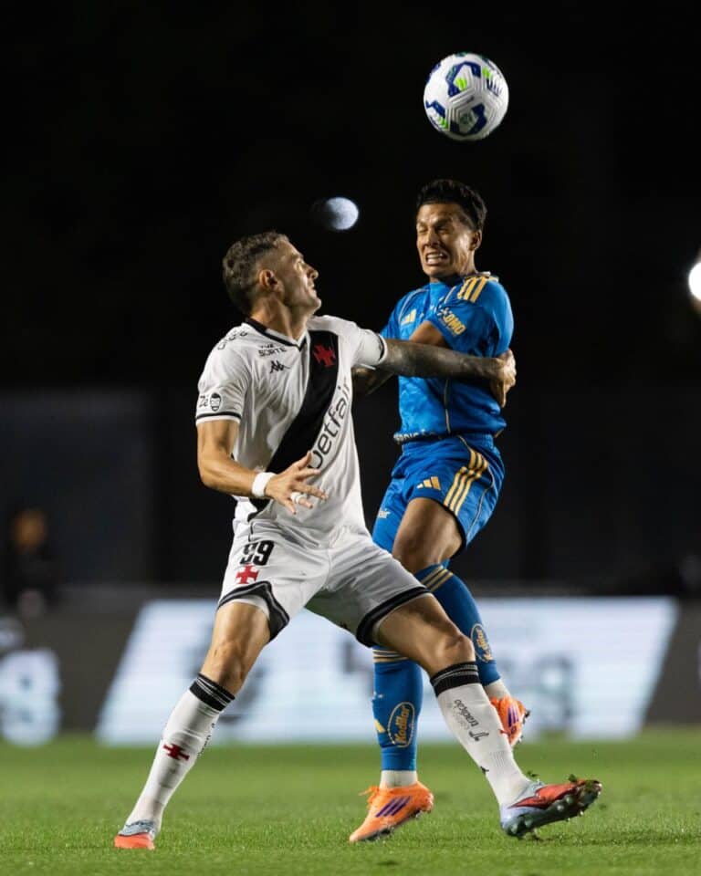 Jogadores de futebol brigando pelo bola em campo.