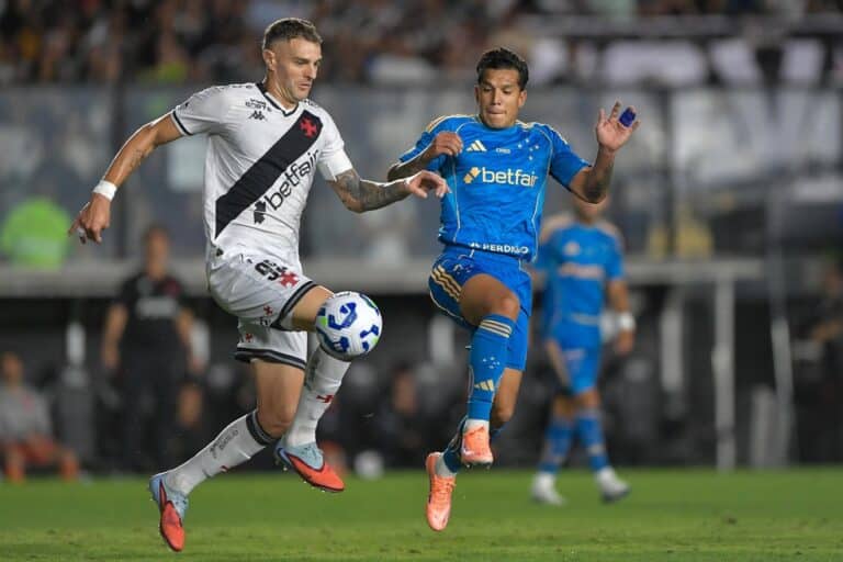 Jogadores do Vasco e adversário disputando a bola no campo.