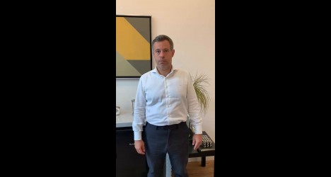 Homem branco de terno em escritório moderno.