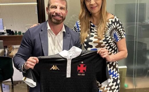 Camiseta do Vasco sendo segurada por duas pessoas.