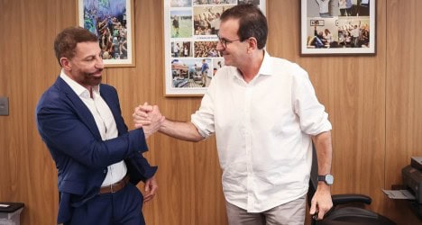 Famosos trocando aperto de mão em reunião.