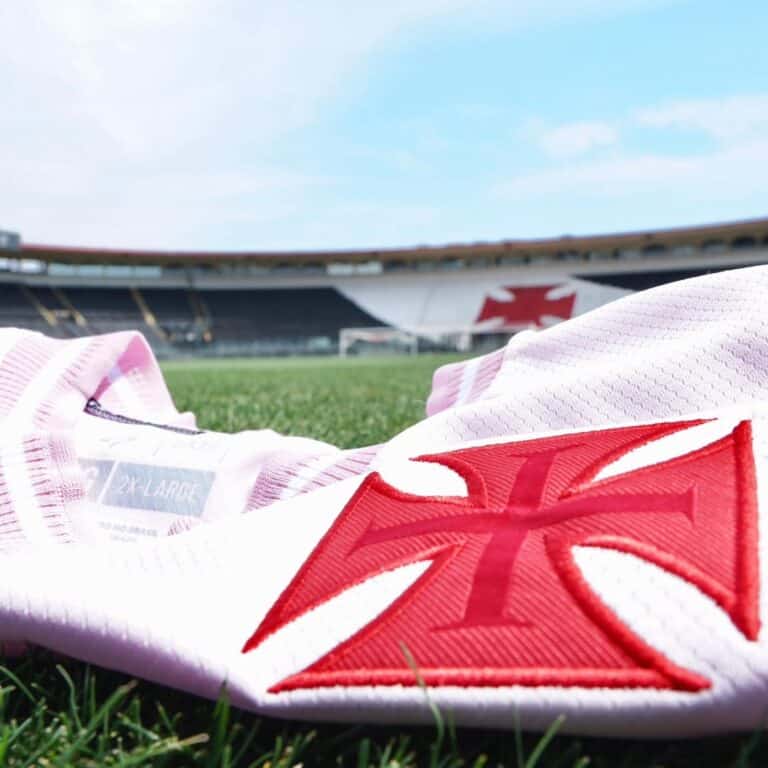 Botas de futebol do Vasco com estádio ao fundo.