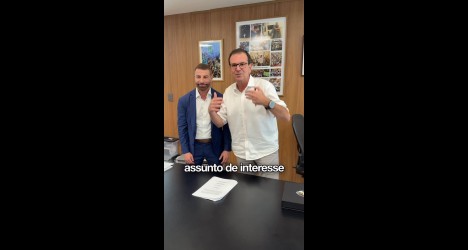 Homens conversando em sala de reunião.