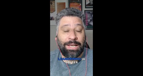 Homem com barba usando fones de ouvido vermelhos.