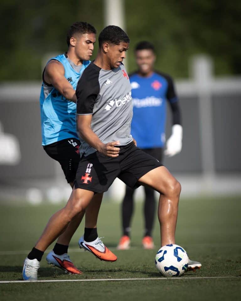 - Jogador treinando futebol com adversário próximo.