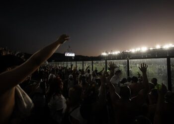 Torcida do Vasco assistindo ao jogo ao pôr do sol.
