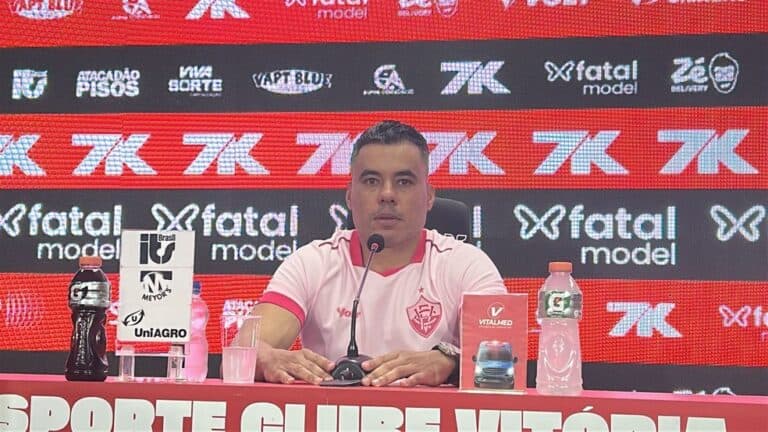 Vasco do Brasil em coletiva de imprensa, homem sentado ao lado de microfone.