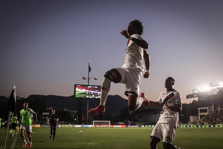Jogador do Vasco pulando em celebração no estádio.