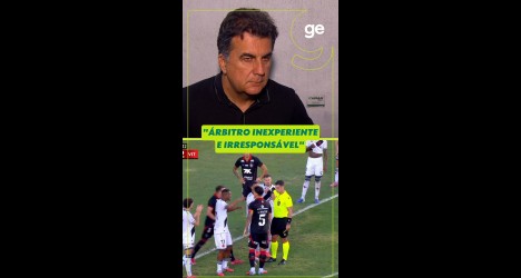 Árbitro em campo durante jogo de futebol.
