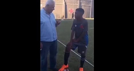 Homem e jogador de futebol conversando.