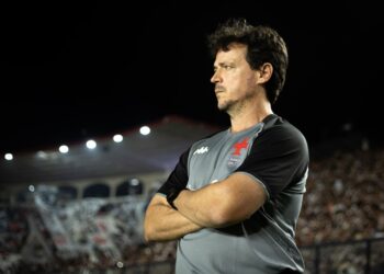 Homem técnico do Vasco com braços cruzados.