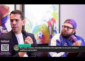 Homens participando de entrevista em ambiente interno.