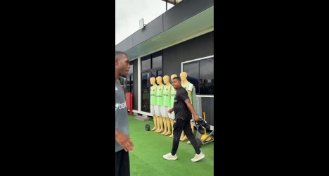 Jogador de futebol na frente de manequins de treino.