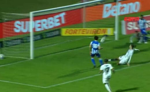 Goleiro salvando um chute na linha do gol.