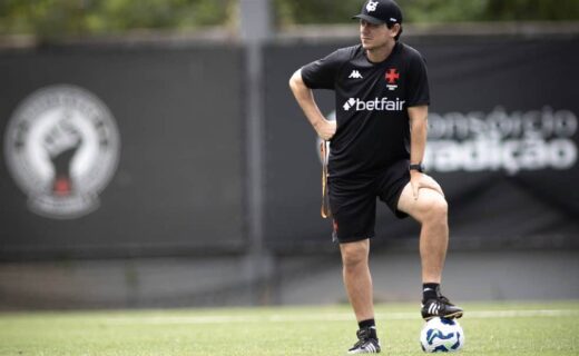 Jogador de futebol treinando com bola no campo.