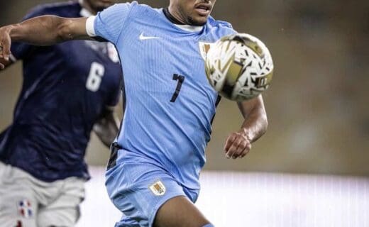 Jogador do Uruguai em ação com a bola durante partida.