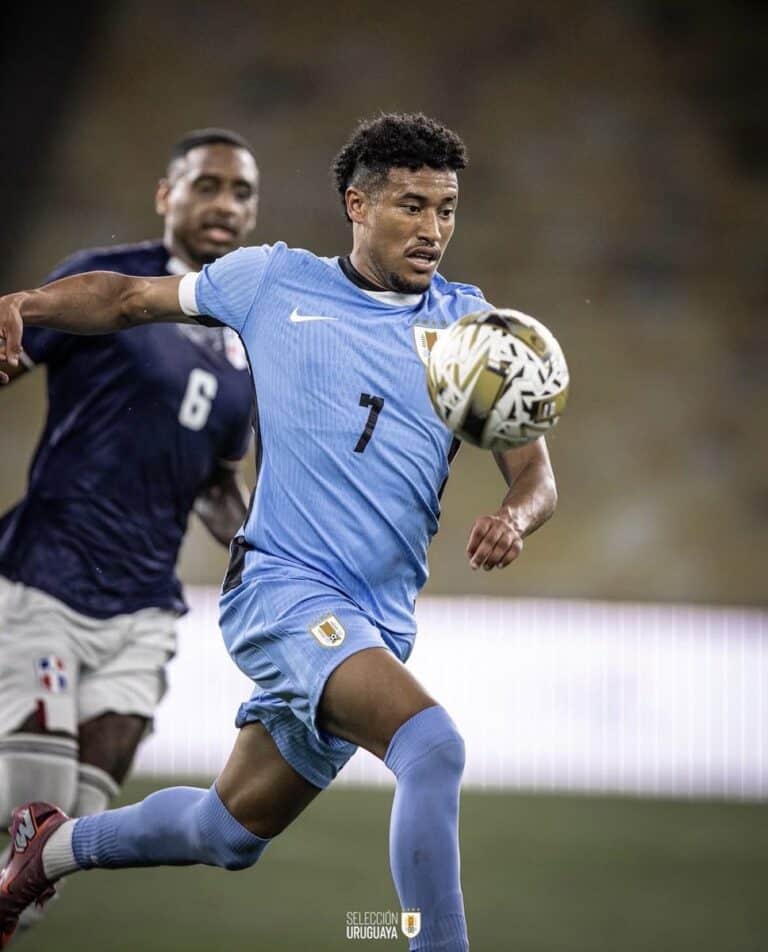 Jogador do Uruguai em ação com a bola durante partida.