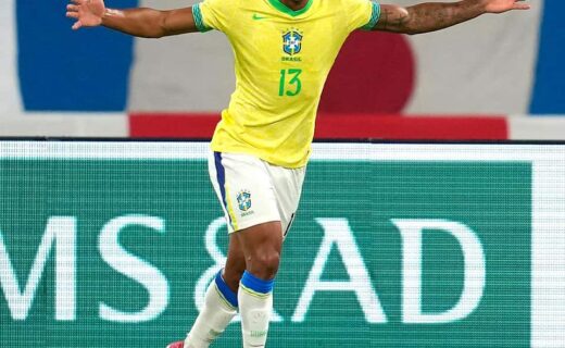 Goleiro comemorando vitória com braços abertos.