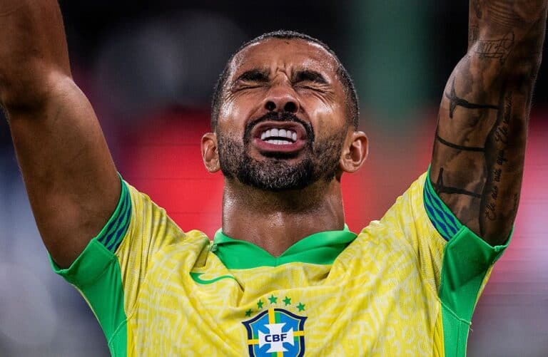 Aterrizado: jogador do Brasil com expressão emotiva, braços levantados, usando uniforme amarelo e verde.