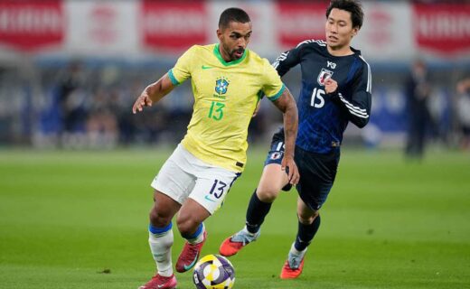Jogador brasileiro com uniforme amarelo e branco em partida contra jogador coreano.