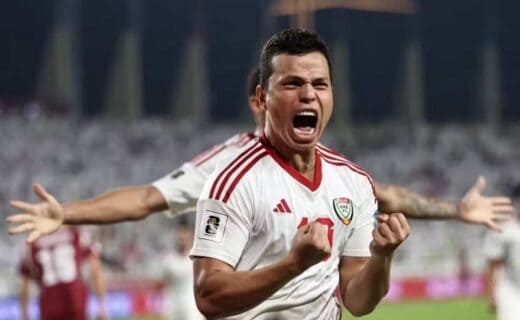 Jogador comemorando com entusiasmo em campo de futebol.