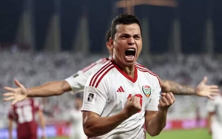 Jogador comemorando com entusiasmo em campo de futebol.