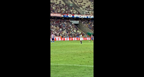 Jogadores em campo durante partida de futebol.