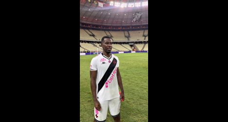 Jogador do Vasco no estádio, camisa branca e calções brancos.