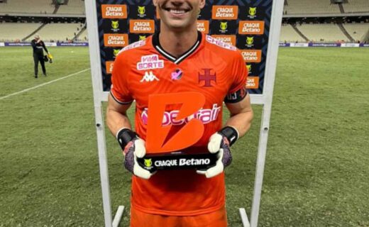 Jogador comemorando vitória com troféu do Vasco.