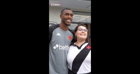 Jogador do Vasco com torcedora sorridente.