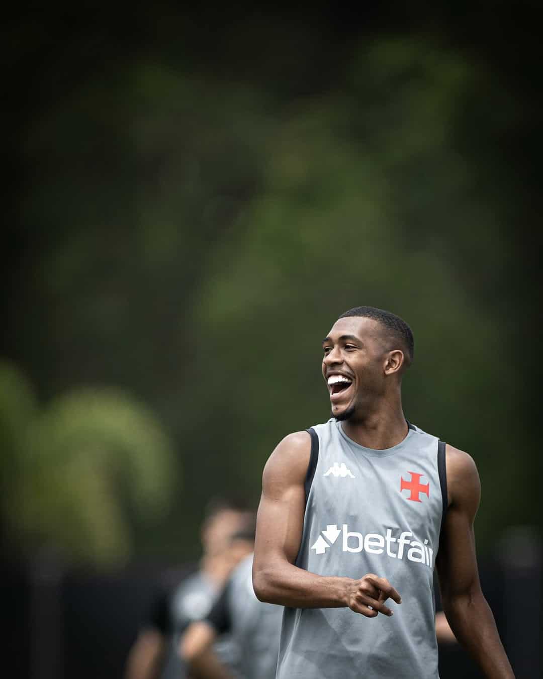 Vasca masculino sorrindo durante treino ao ar livre.