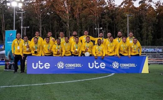 Jogadores do time posando no campo de futebol.