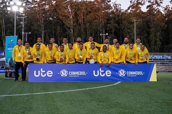 Jogadores do time posando no campo de futebol.