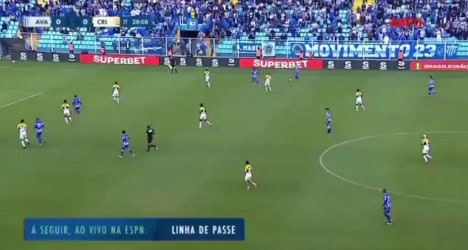 Jogadores em campo durante partida de futebol.