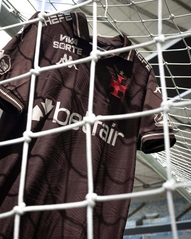 Camisa de futebol do Vasco da Gama no estádio, vista através da rede de proteção.