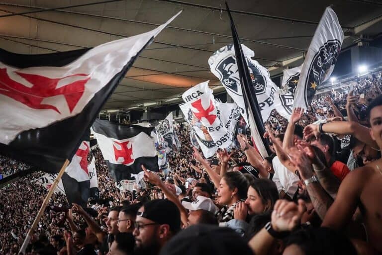 Bandeiras do Vasco sendo agitadas na torcida.