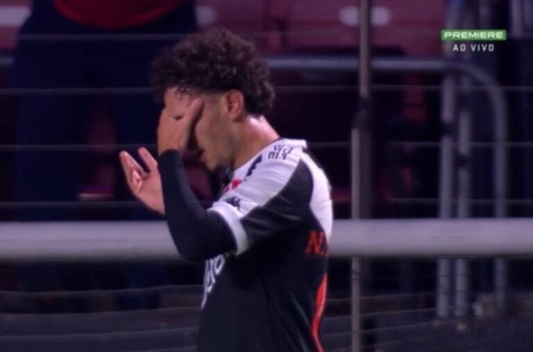 Jogador Vasco com expressão de frustração, cobrindo o rosto com a mão.