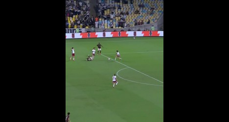 Jogadores de futebol em campo durante partida vibrante.