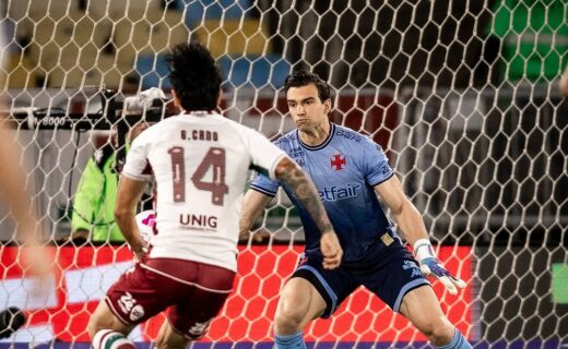 Goleiro do Vasco defendendo chute de atacante do Fluminense.