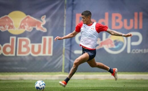 Jogador do Vasco chuta bola em treino no campo.