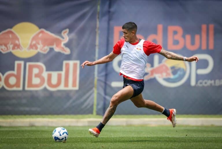 Jogador do Vasco chuta bola em treino no campo.